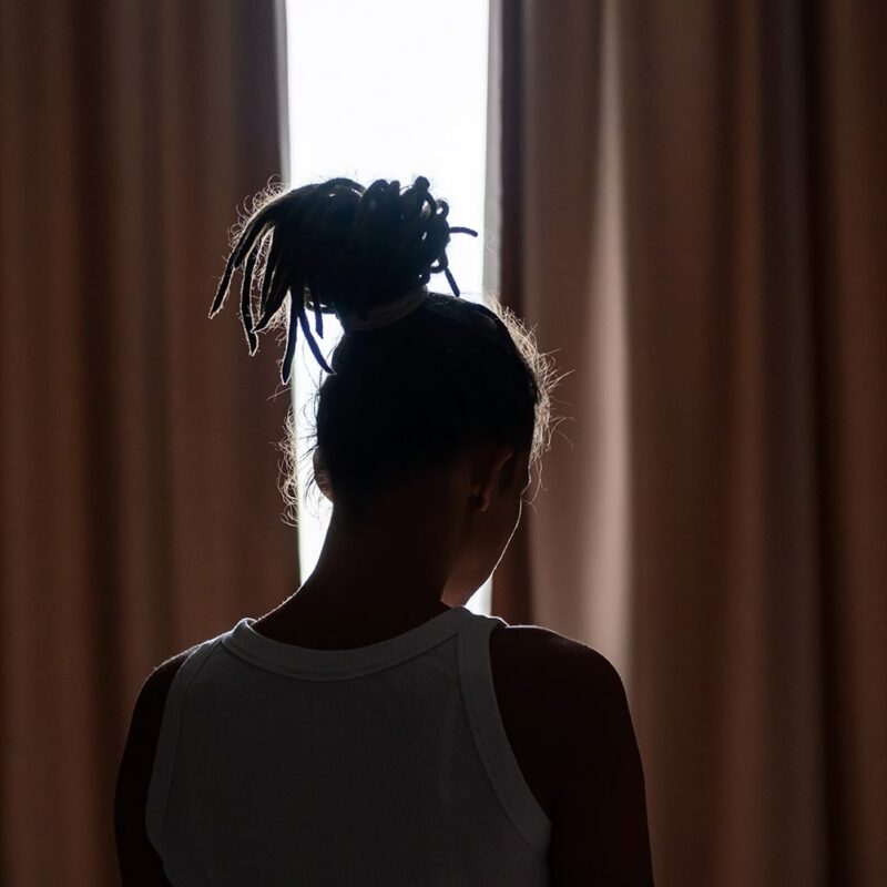 Worried parent looking at Christmas decorations, contemplating child contact arrangements