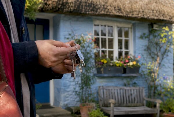 Hands holding keys by British red-brick house door