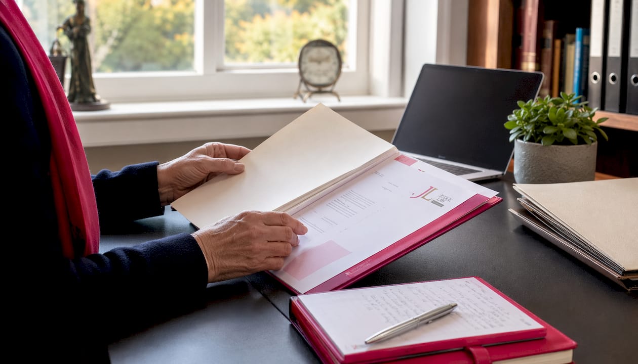 Older hands reviewing leasehold paperwork on desk