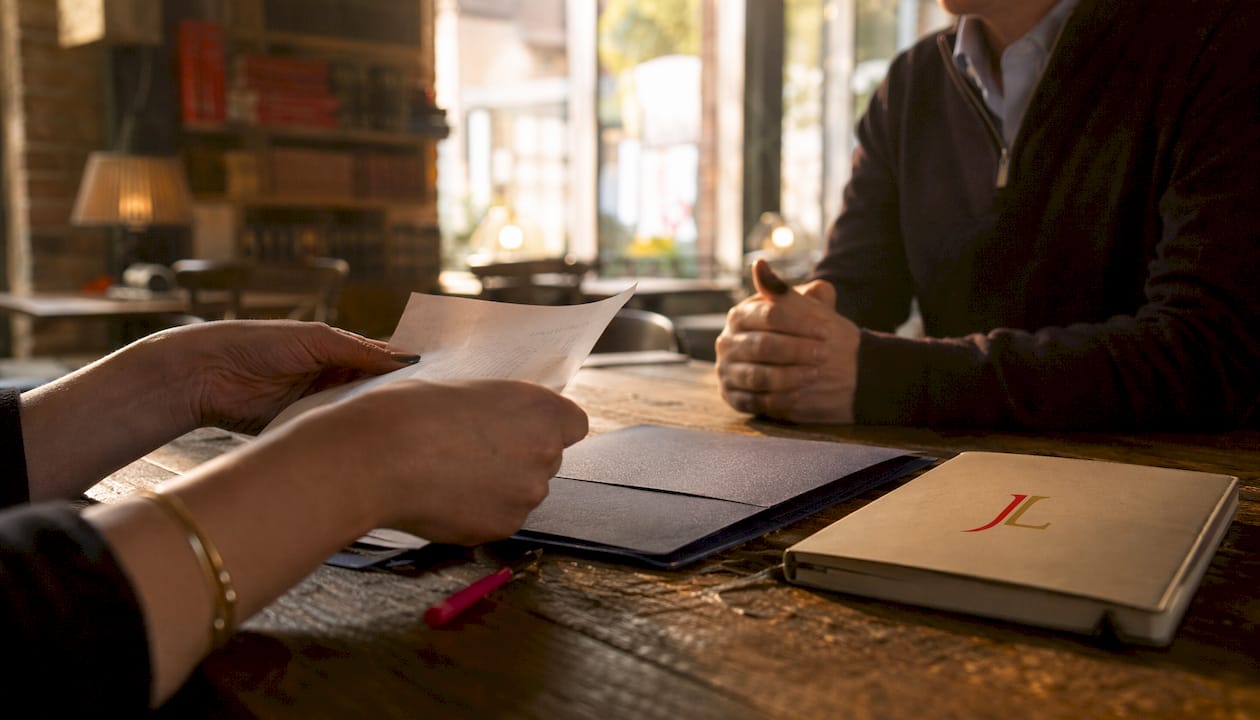 Silhouetted figures reviewing payment papers at table