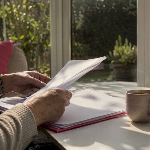 Hands arranging legal documents on warm wooden desk