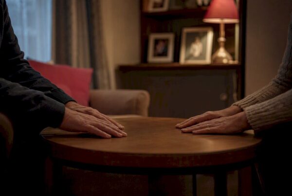 Hands resting on kitchen table in UK home